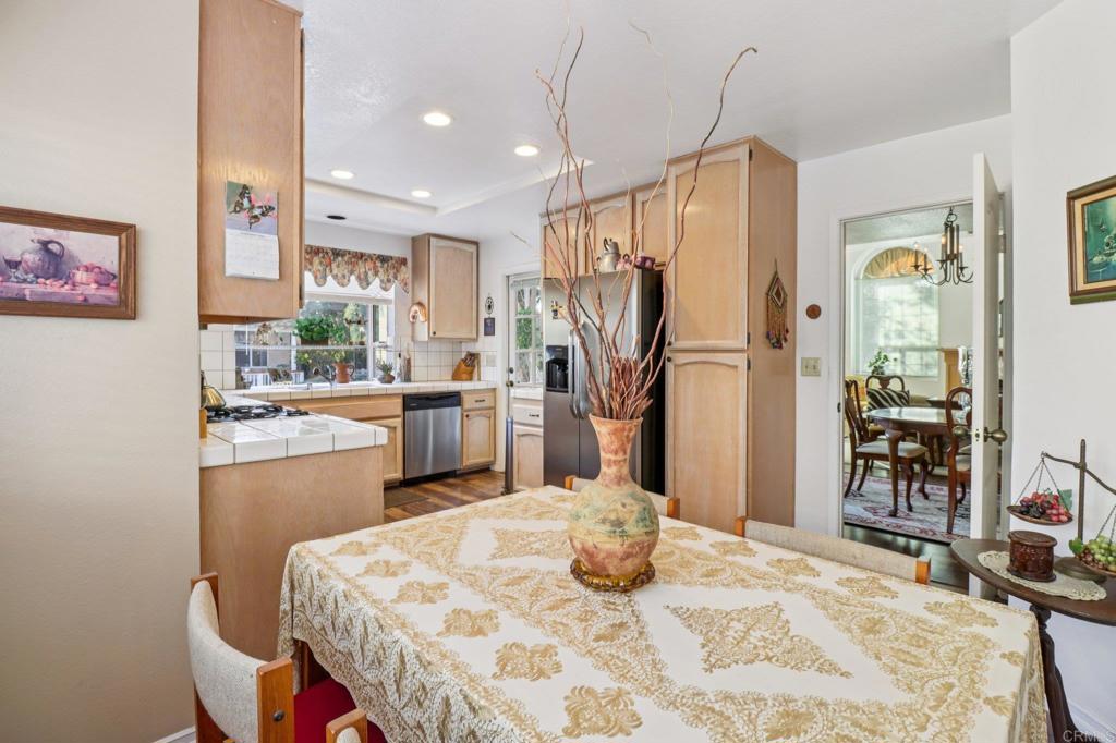 7747 Caminito Monarca, Unit 100 Carlsbad, CA 92009 - Photo 16 of 67 a kitchen with refrigerator cabinets dining table and chairs