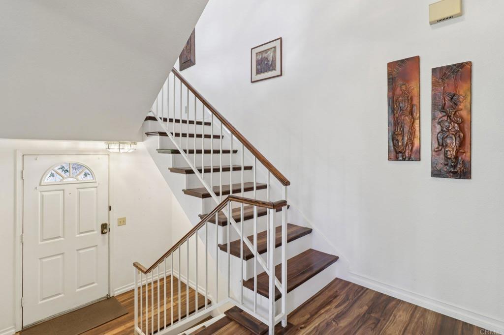 7747 Caminito Monarca, Unit 100 Carlsbad, CA 92009 - Photo 23 of 67 a view of staircase with wooden floor and white walls