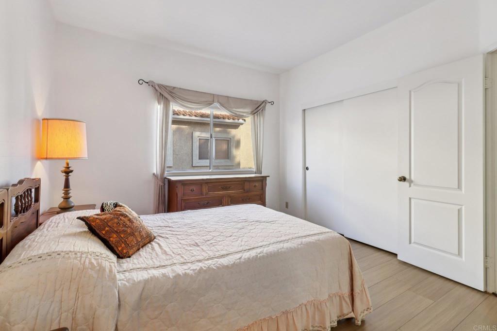 7747 Caminito Monarca, Unit 100 Carlsbad, CA 92009 - Photo 28 of 67 a bedroom with a bed and a lamp