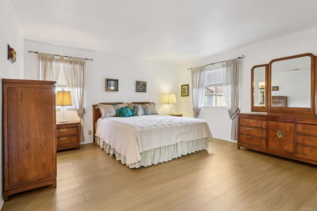7747 Caminito Monarca, Unit 100 Carlsbad, CA 92009 - Photo 49 of 67 a spacious bedroom with a bed dresser and a large window