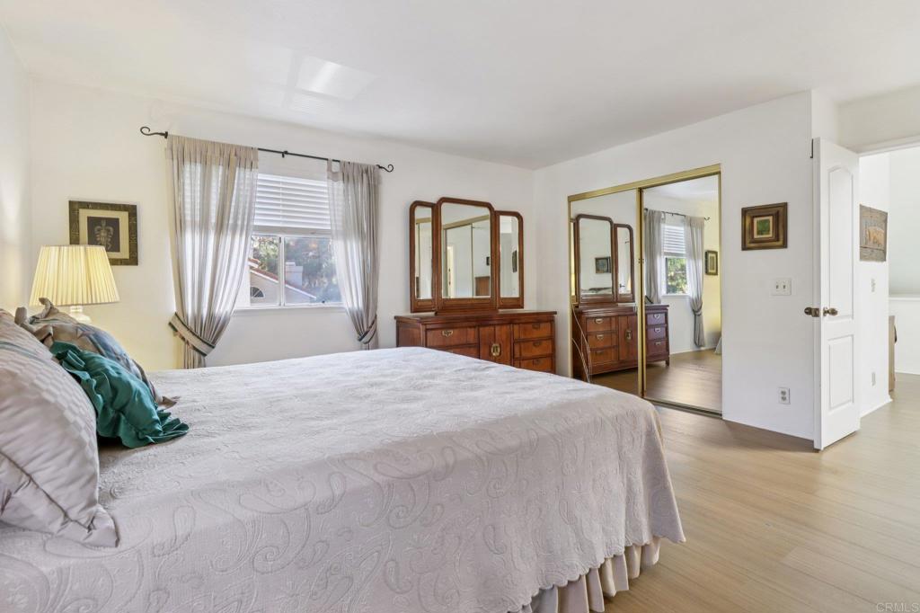 7747 Caminito Monarca, Unit 100 Carlsbad, CA 92009 - Photo 53 of 67 a bedroom with a large bed and wooden floor