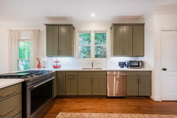 a kitchen with stainless steel appliances granite countertop sink stove top oven and cabinets