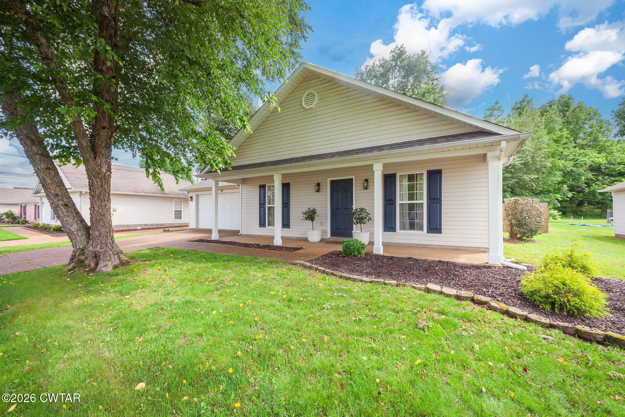 a view of a house with backyard and a tree