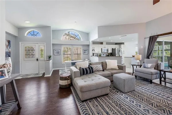 a living room with furniture wooden floor and a large window