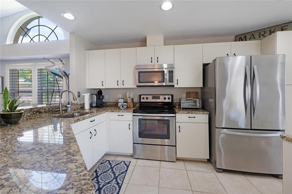 641 St Andrews Boulevard, Unit 1081 Naples, FL 34113 - Photo 13 of 31 a kitchen with a refrigerator sink and cabinets