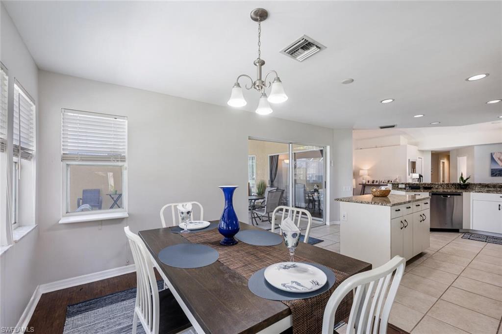 641 St Andrews Boulevard, Unit 1081 Naples, FL 34113 - Photo 17 of 31 a view of a dining room with furniture and wooden floor