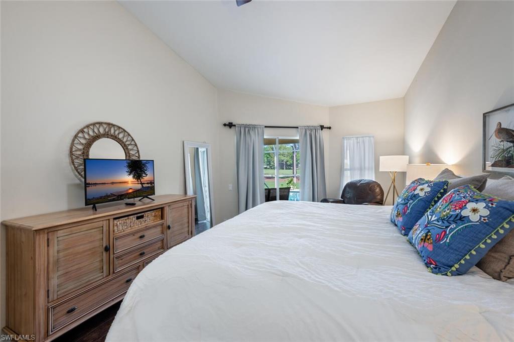 641 St Andrews Boulevard, Unit 1081 Naples, FL 34113 - Photo 19 of 31 a bedroom with a bed and a dresser with mirror