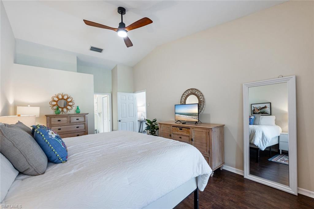 641 St Andrews Boulevard, Unit 1081 Naples, FL 34113 - Photo 20 of 31 a bedroom with a bed and a chandelier
