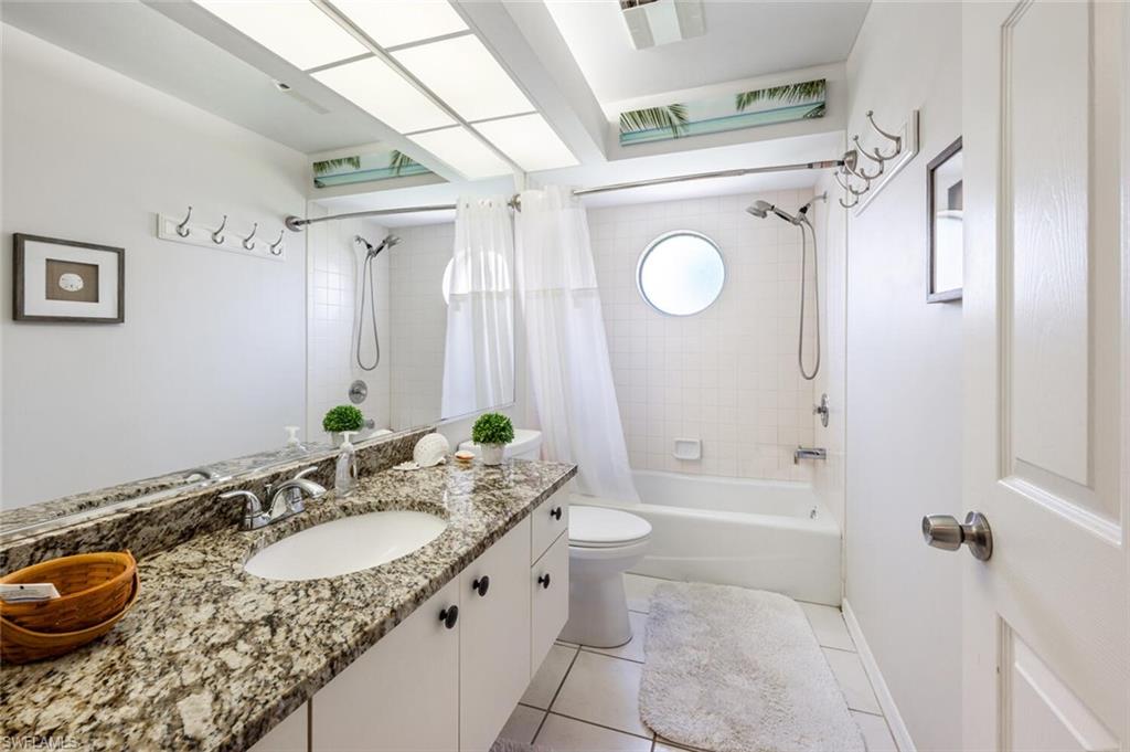 641 St Andrews Boulevard, Unit 1081 Naples, FL 34113 - Photo 24 of 31 a bathroom with a granite countertop sink toilet and shower
