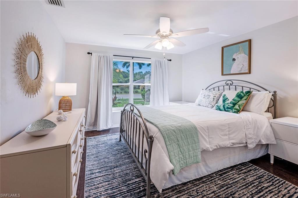 641 St Andrews Boulevard, Unit 1081 Naples, FL 34113 - Photo 25 of 31 a bedroom with a bed and a chandelier