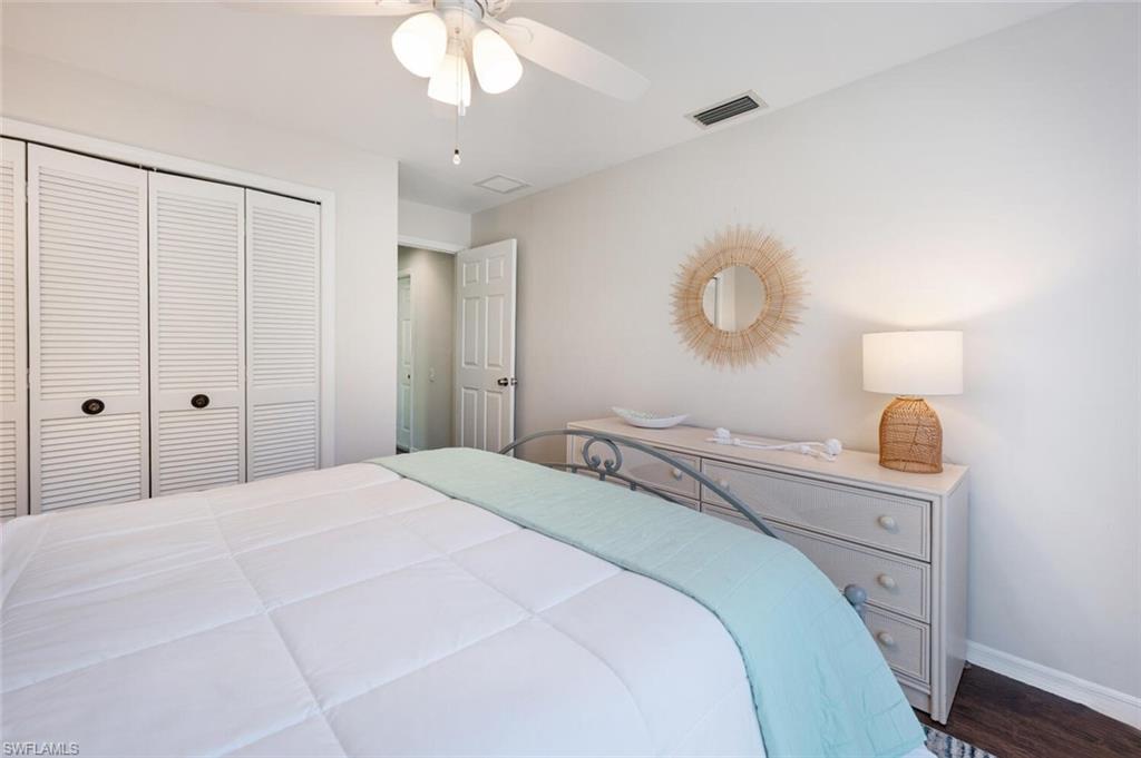 641 St Andrews Boulevard, Unit 1081 Naples, FL 34113 - Photo 26 of 31 a bedroom with a bed and a chandelier