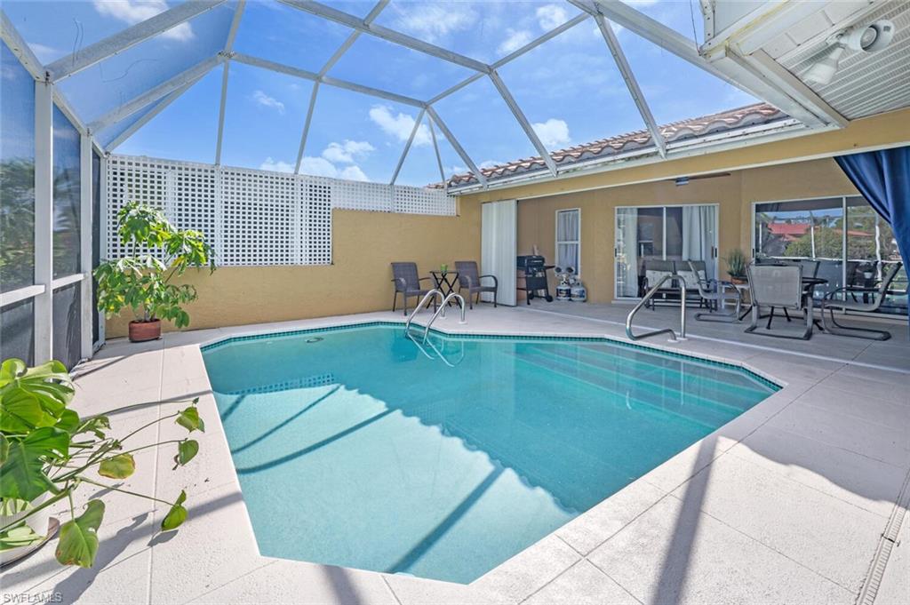641 St Andrews Boulevard, Unit 1081 Naples, FL 34113 - Photo 29 of 31 a swimming pool with outdoor seating and yard