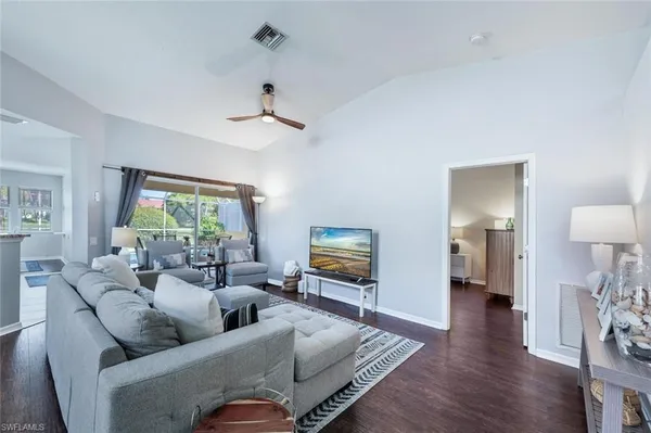 a living room with furniture and a wooden floor