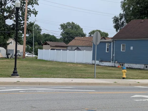 a view of a house with a big yard and large trees