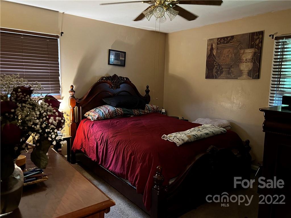 196 London Road Asheville, NC 28803 - Photo 11 of 14 a bedroom with a bed and a chandelier