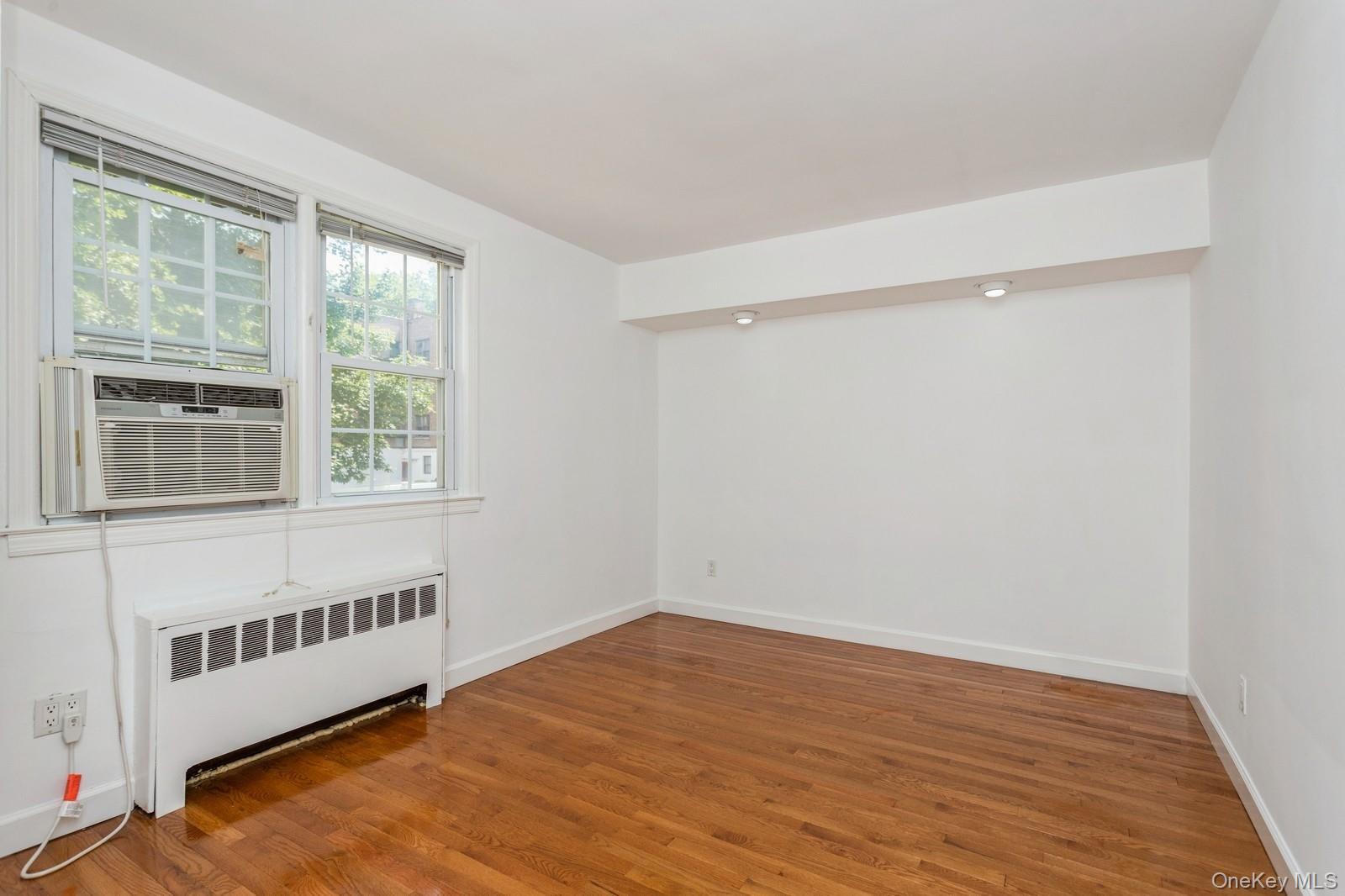 51 Cross Street, Unit 3A Yonkers, NY 10708 - Photo 12 of 17 Unfurnished room featuring radiator, wood finished floors, and cooling unit