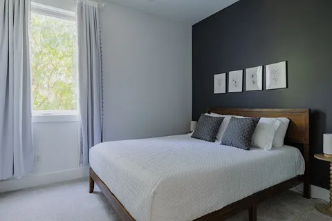 a large bed in a bedroom next to a window