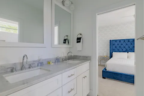 a en suite bathroom with a double vanity sink and a mirror
