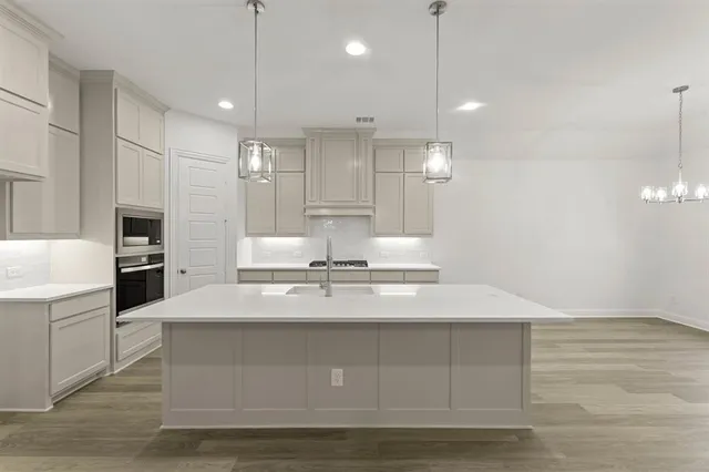 a large kitchen with kitchen island a sink stainless steel appliances and cabinets