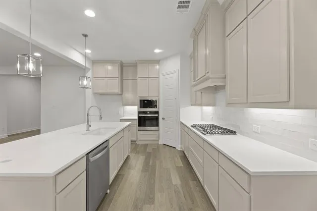 a large kitchen with stainless steel appliances granite countertop a lot of counter space sink and cabinets