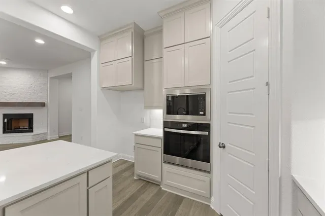 a kitchen with stainless steel appliances a stove and white cabinets