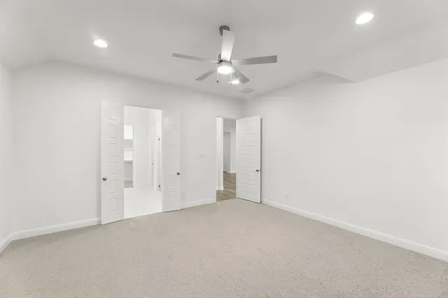 an empty room with fan and windows
