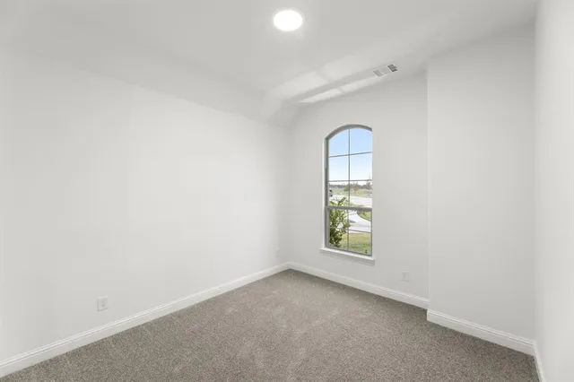 an empty room with windows and mirror