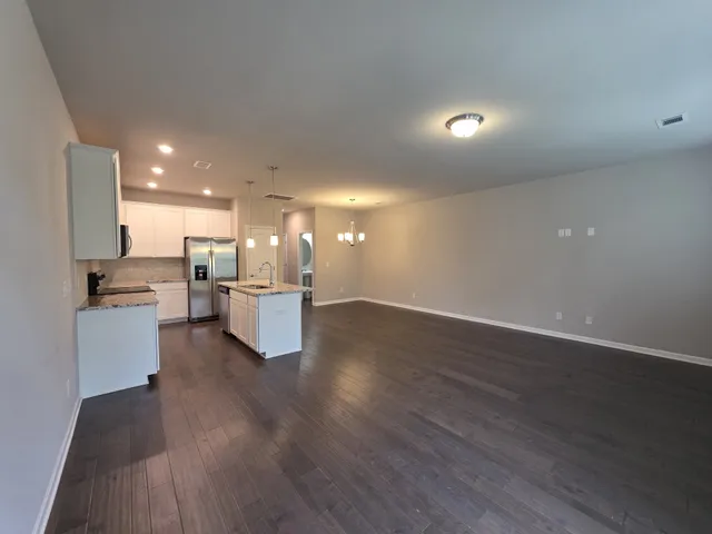 a large kitchen with cabinets wooden floor and stainless steel appliances