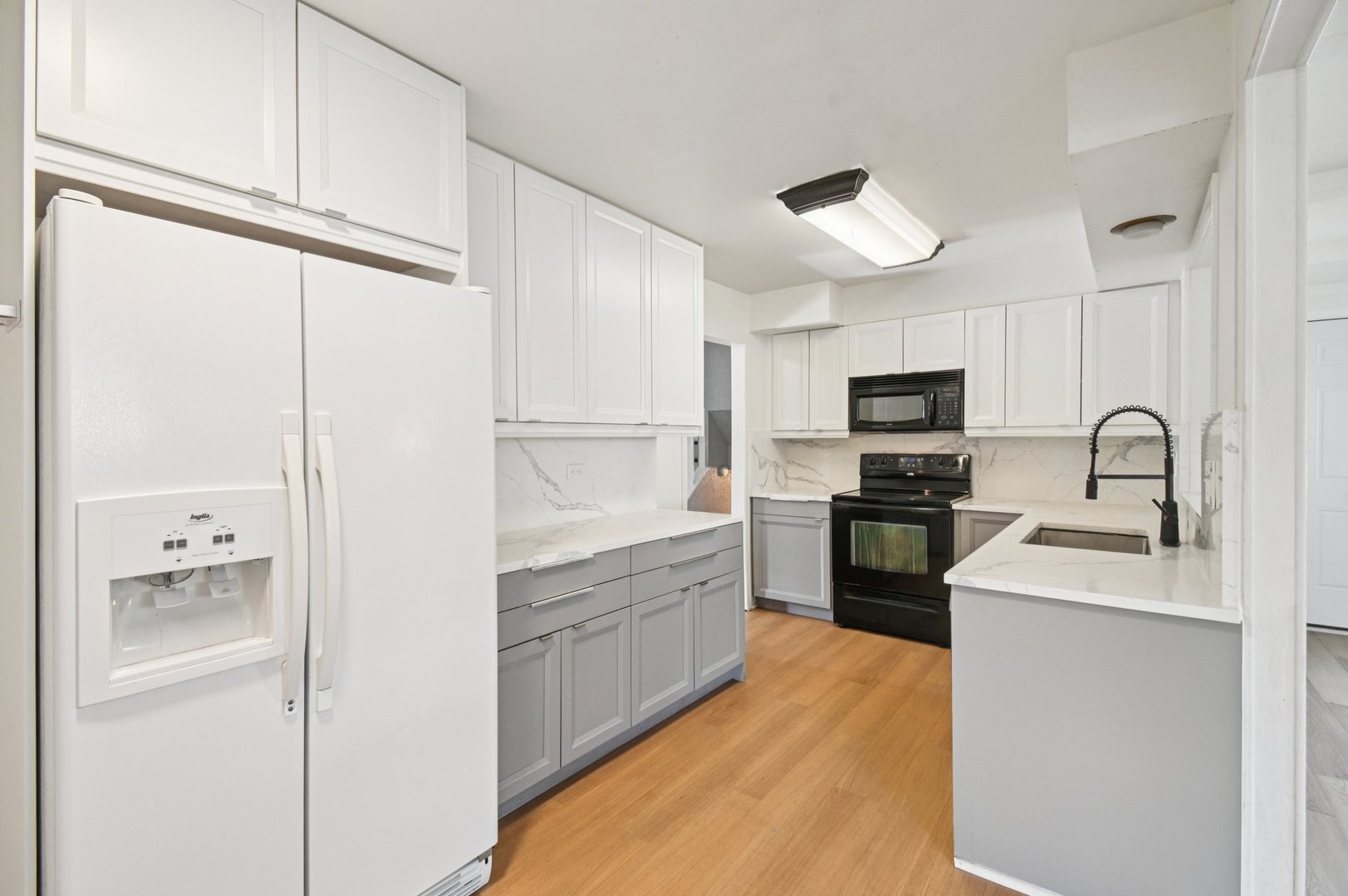 207 North Idlewild Avenue Mundelein, IL 60060 - Photo 12 of 46 a kitchen with white cabinets and stainless steel appliances