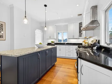 a kitchen with stainless steel appliances granite countertop wooden cabinets sink and a stove