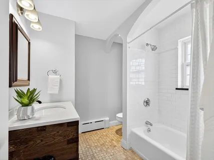 a bathroom with a granite countertop sink a toilet and a bathtub