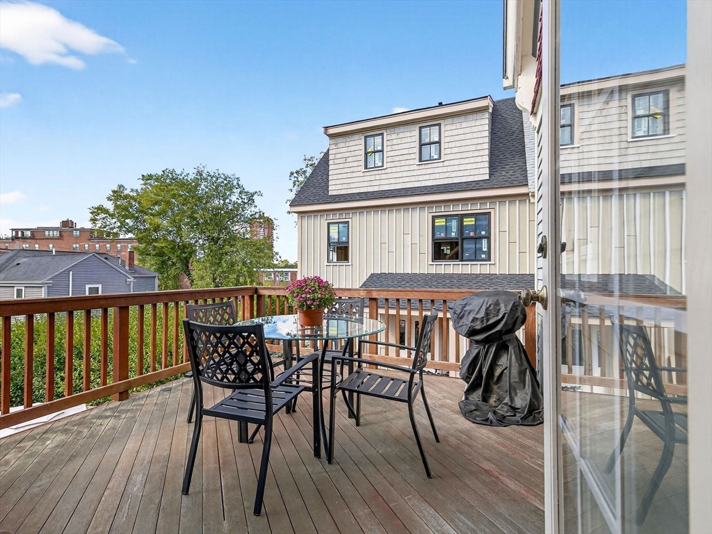 24 Evergreen Street, Unit 2 Boston, MA 02130 - Photo 14 of 31 a view of a roof deck with table and chairs with wooden floor and fence