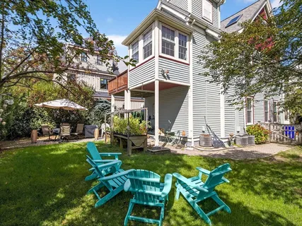 a view of a chair and table in backyard of the house