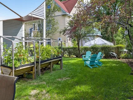 a backyard of a house with table and chairs under an umbrella