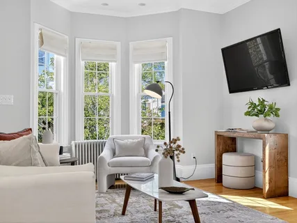 a living room with furniture a flat screen tv and a fireplace