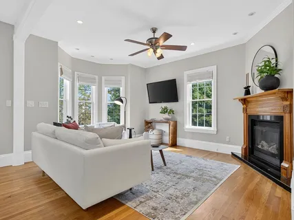 a living room with furniture a fireplace and a flat screen tv