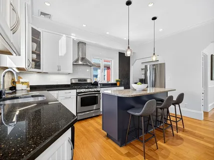 a kitchen with stainless steel appliances granite countertop a sink a stove a refrigerator and island