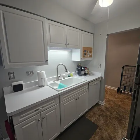 a kitchen with a stove refrigerator and white cabinets