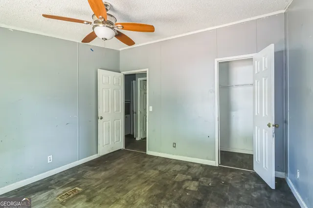 an empty room with closet and a chandelier fan
