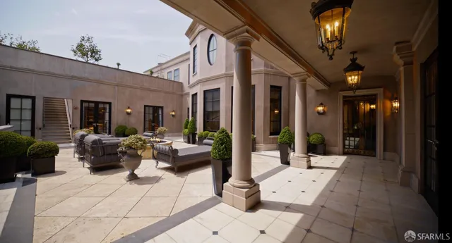 a view of staircase with lots of frames on wall and windows
