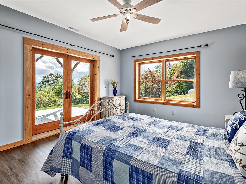 866 Pine Tree Road Spruce Pine, NC 28777 - Photo 21 of 38 a bedroom with a bed and a large window with wooden floor
