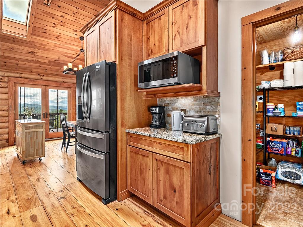 866 Pine Tree Road Spruce Pine, NC 28777 - Photo 6 of 38 a kitchen with stainless steel appliances granite countertop a refrigerator a stove and a sink with wooden floor