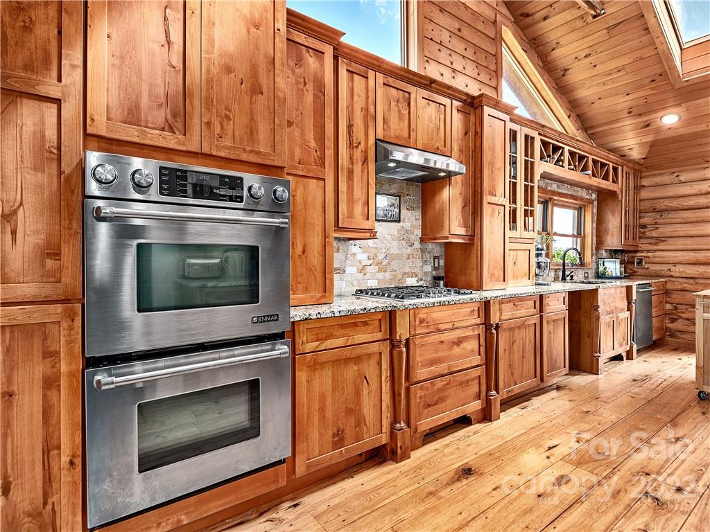 866 Pine Tree Road Spruce Pine, NC 28777 - Photo 8 of 38 a kitchen with granite countertop wooden cabinets stainless steel appliances and a counter space