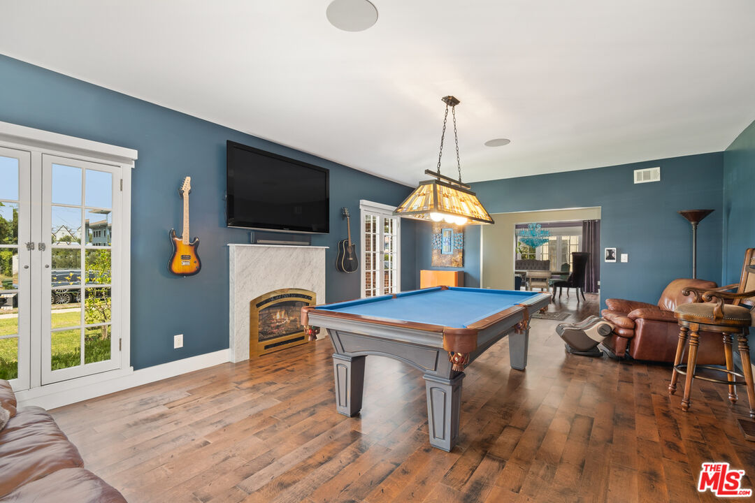 1632 Virginia Road Los Angeles, CA 90019 - Photo 7 of 26 a dining room with furniture wooden floor a flat screen tv and a chandelier