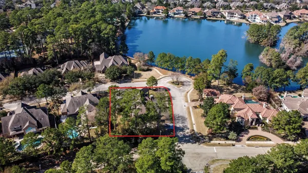 an aerial view of a house with a yard and lake view