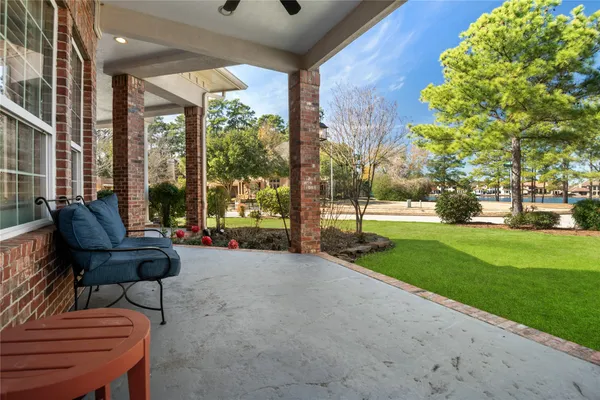 a view of a patio with couches and table and chairs with wooden fence and plants