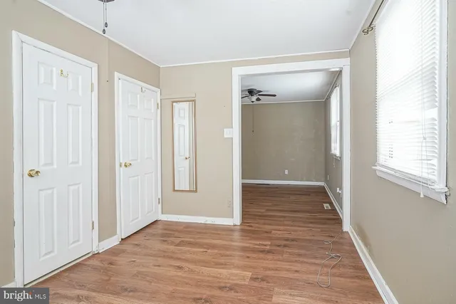 a view of a hallway with wooden floor and closet area