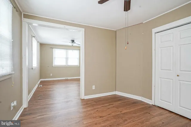a view of an empty room with window and wooden floor