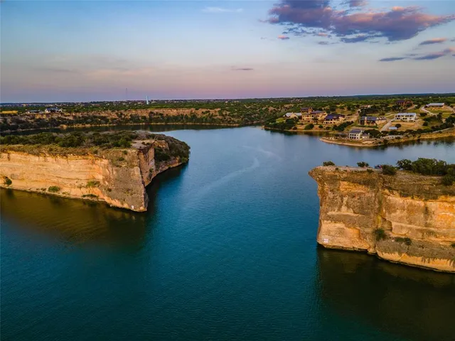 an aerial view of ocean and residential houses with outdoor space