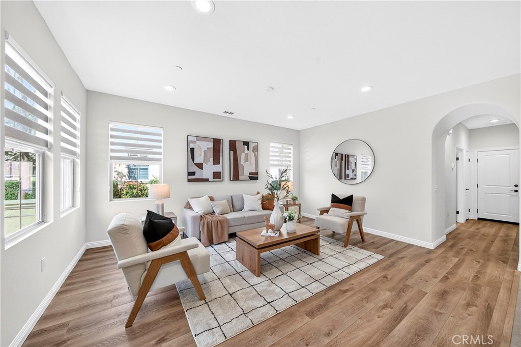 341 Adalina Lane Brea, CA 92821 - Photo 18 of 60 a living room with couches a large mirror and a dining table with wooden floor